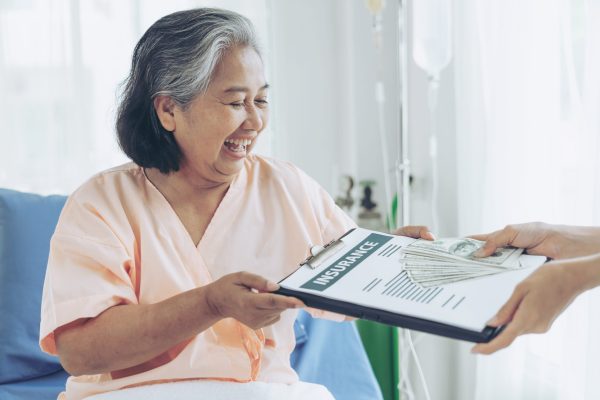 elderly patients injury  woman on Patient's bed in hospital  holding us dollar bills feel happy from getting insurance money From insurance companies